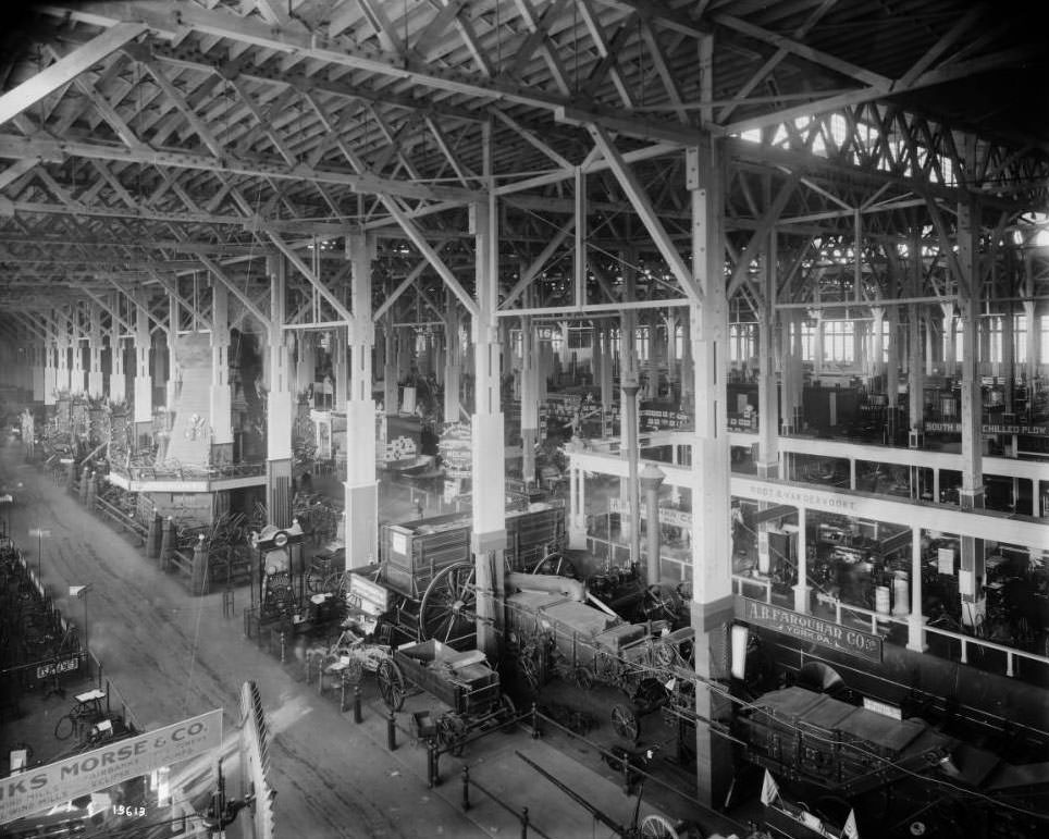 An overhead view of exhibits of agricultural machinery and implements on the floor of the Agriculture palace at the Louisiana Purchase Exposition