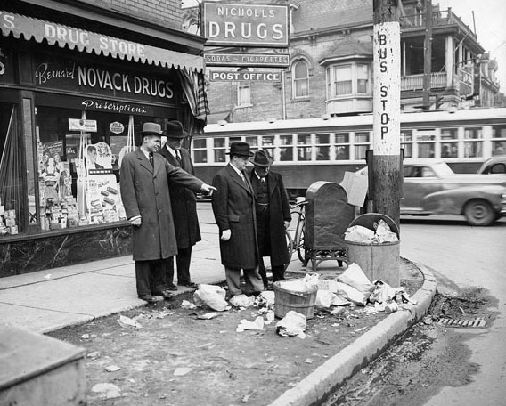 Street cleaning team inspects a pile of garbage, 1940s