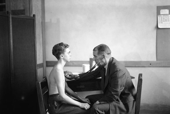 Doctor performs a routine health examination at a Toronto school, 1940s