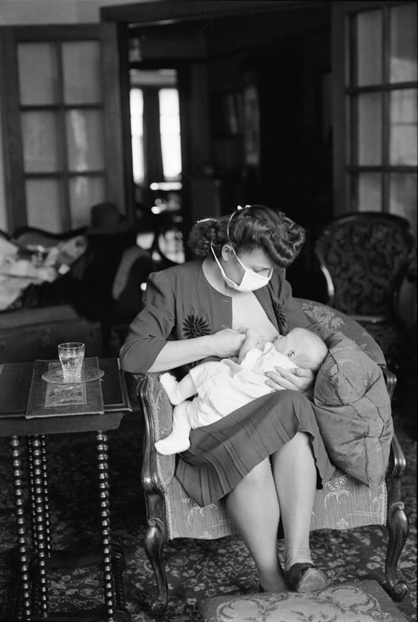 Visiting nurse feeds a baby, 1940s