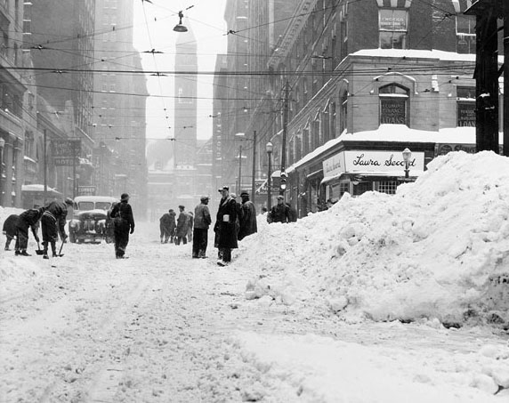 Crews armed with shovels attempt to dig out a clear path on Bay Street, 1940s