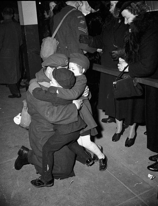 Returning soldier embraces children at Union Station, 1940s