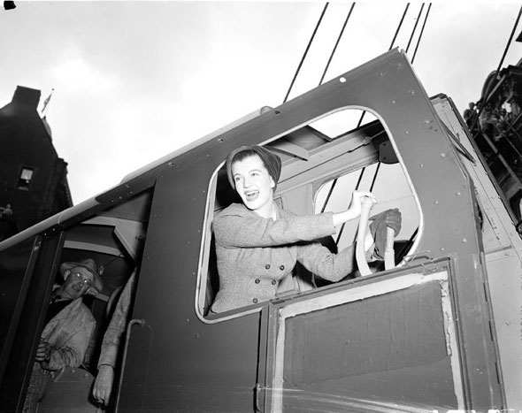 Dignitaries pose for ceremonial groundbreaking photos in the cab of a digger.