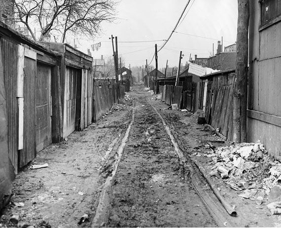 A muddy laneway that had drawn the attention of the Department of Street Cleaning, 1940s
