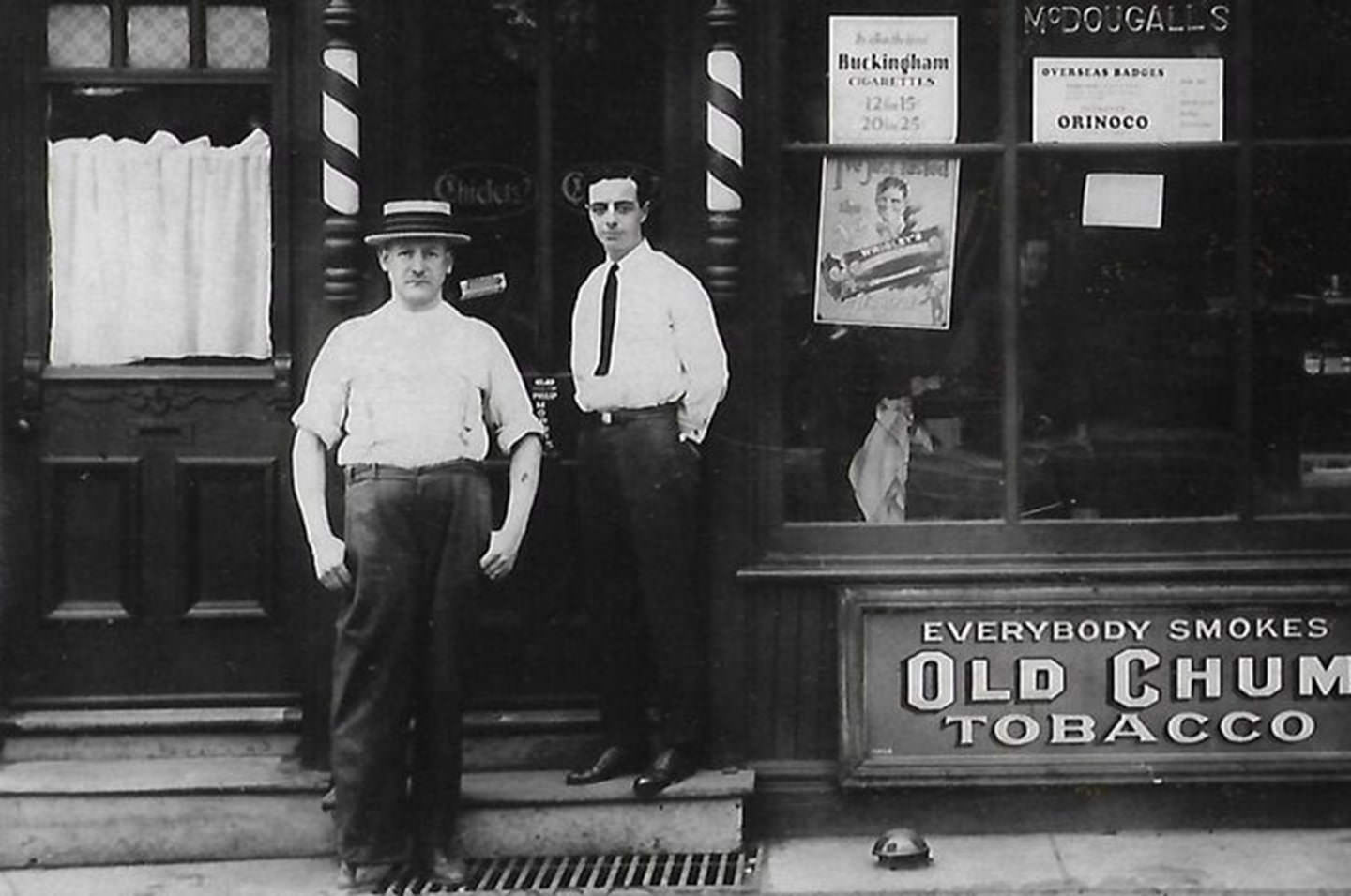 Daniel McDougall and Bobby Mitchell outside barber shop at 625 Gerrard Street East, sometime just after 1912.