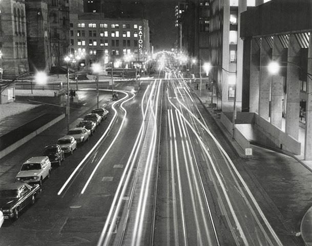 Queen Street, looking east towards Bay Street. Time lapse photo taken from the bridge connecting Nathan Phillips Square to the Sheraton Hotel, 1974