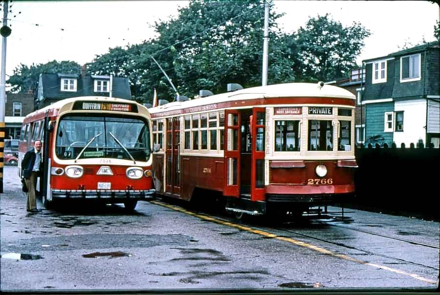 A charter of TTC Peter Witt streetcar 2766, TTC 7528 is a 1972 General Motors Diesel Division T6H 5395 model bus and is doing Ontario Place express duty, 1976