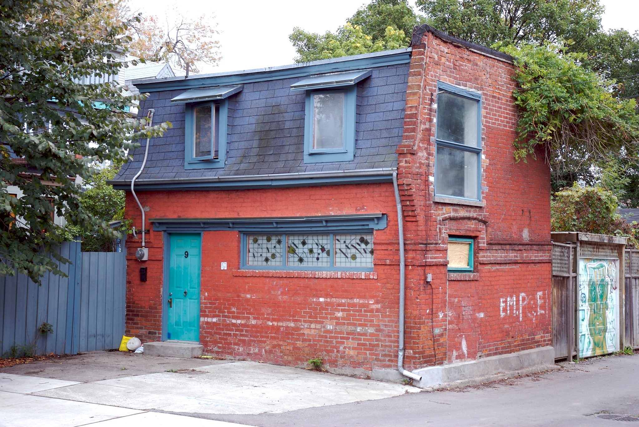 Toronto has a lot of tiny houses scattered around the city on small streets, backyards and lane-ways. This one is at #9 Lobb Avenue between Crawford & Shaw, north of Queen street west, 1990s