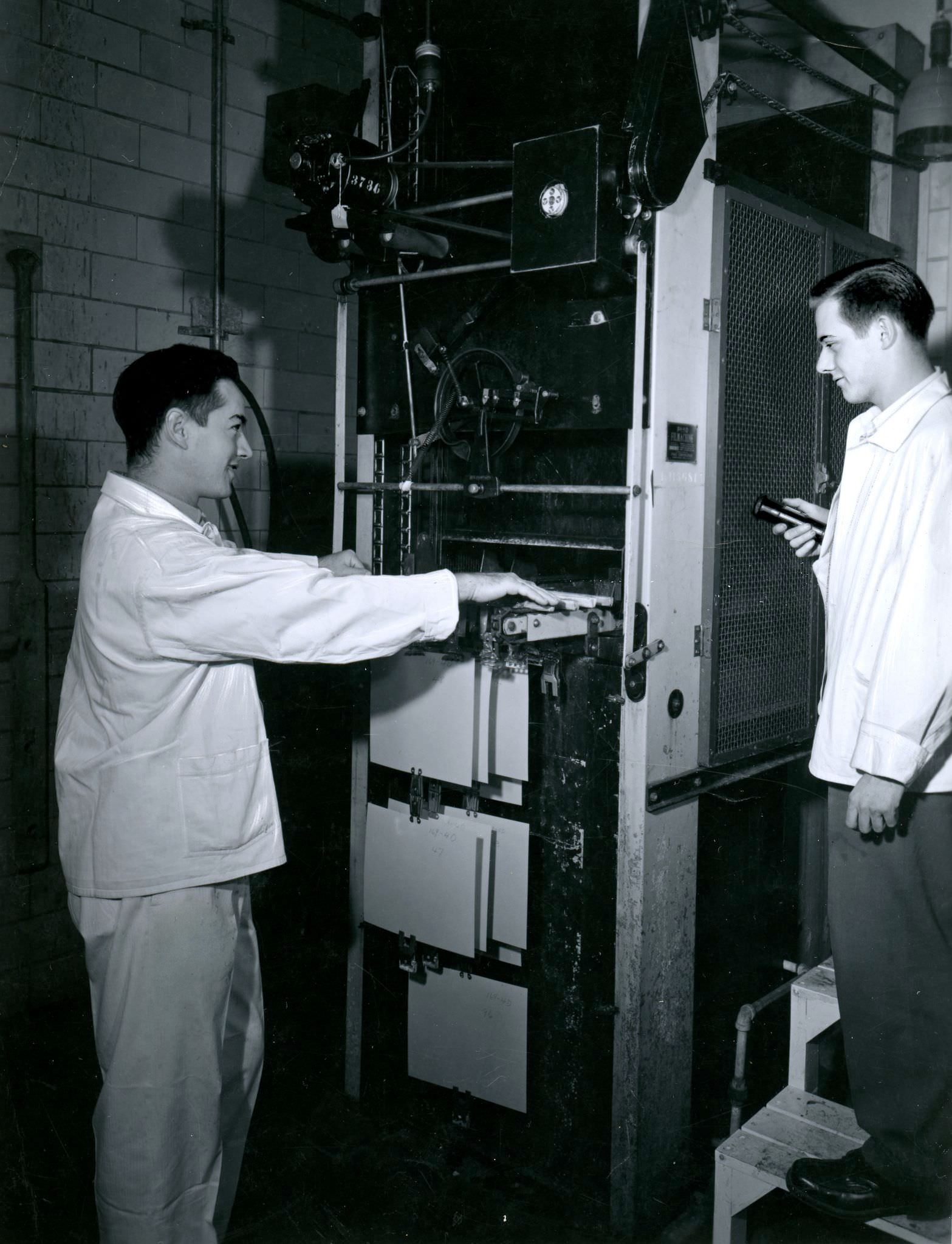 Employees operating Pako Corp. Filmachine at the 'Kodak Heights' facility, 1950