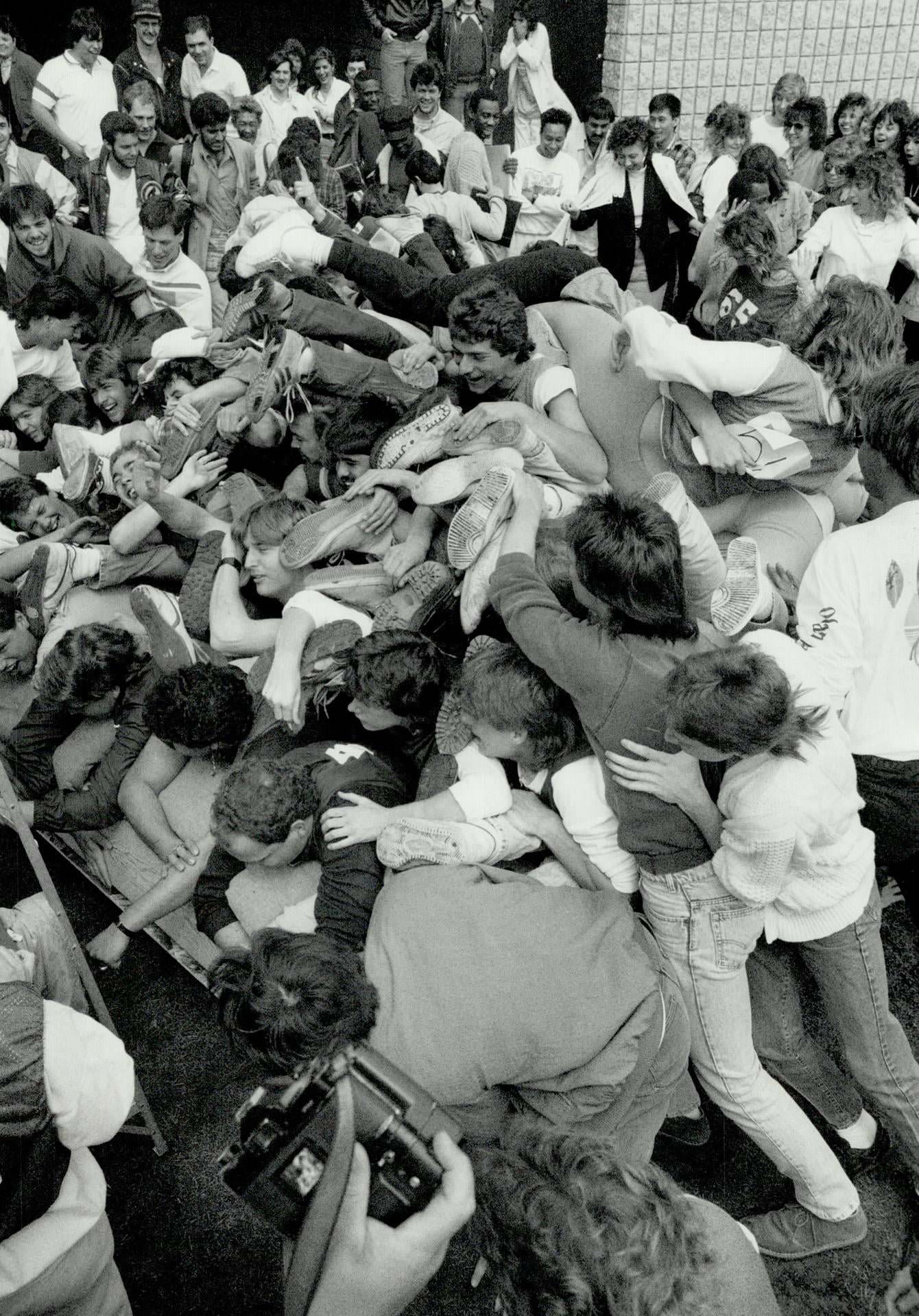 Piling on for a place in history, Sixty-five Centennial College students pile on to a waterbed yesterday at their Scarborough campus in a bid to win a place in the Guinness Book of World Records- 1987