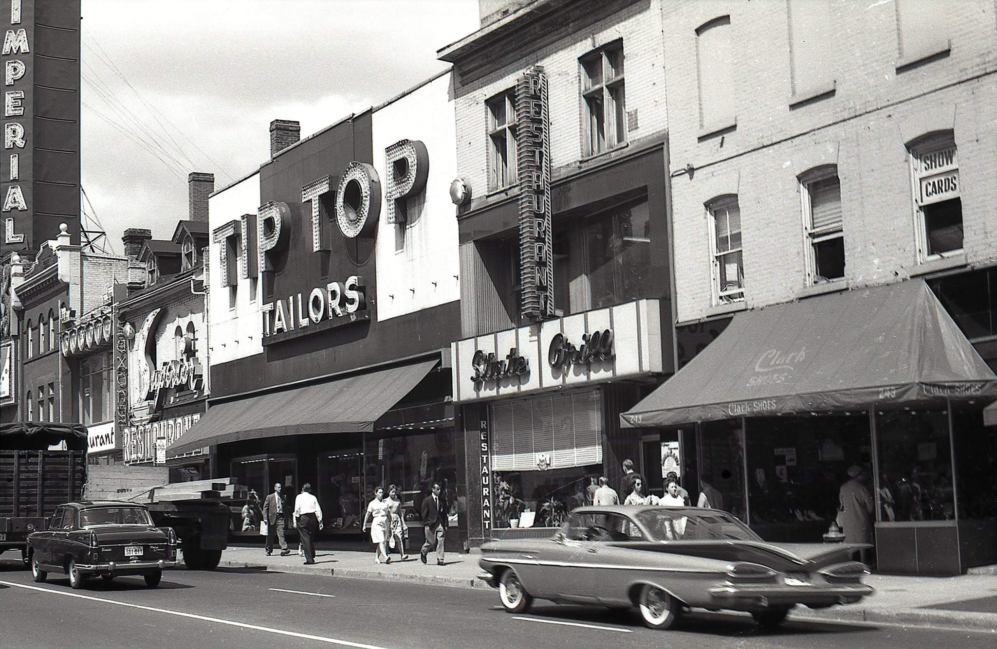 243-255 Yonge Street in 1962 Clark Shoes State Grill Tip Top Tailors Superior Tea Rooms Imperial Theatre sign visible a few shops to the north