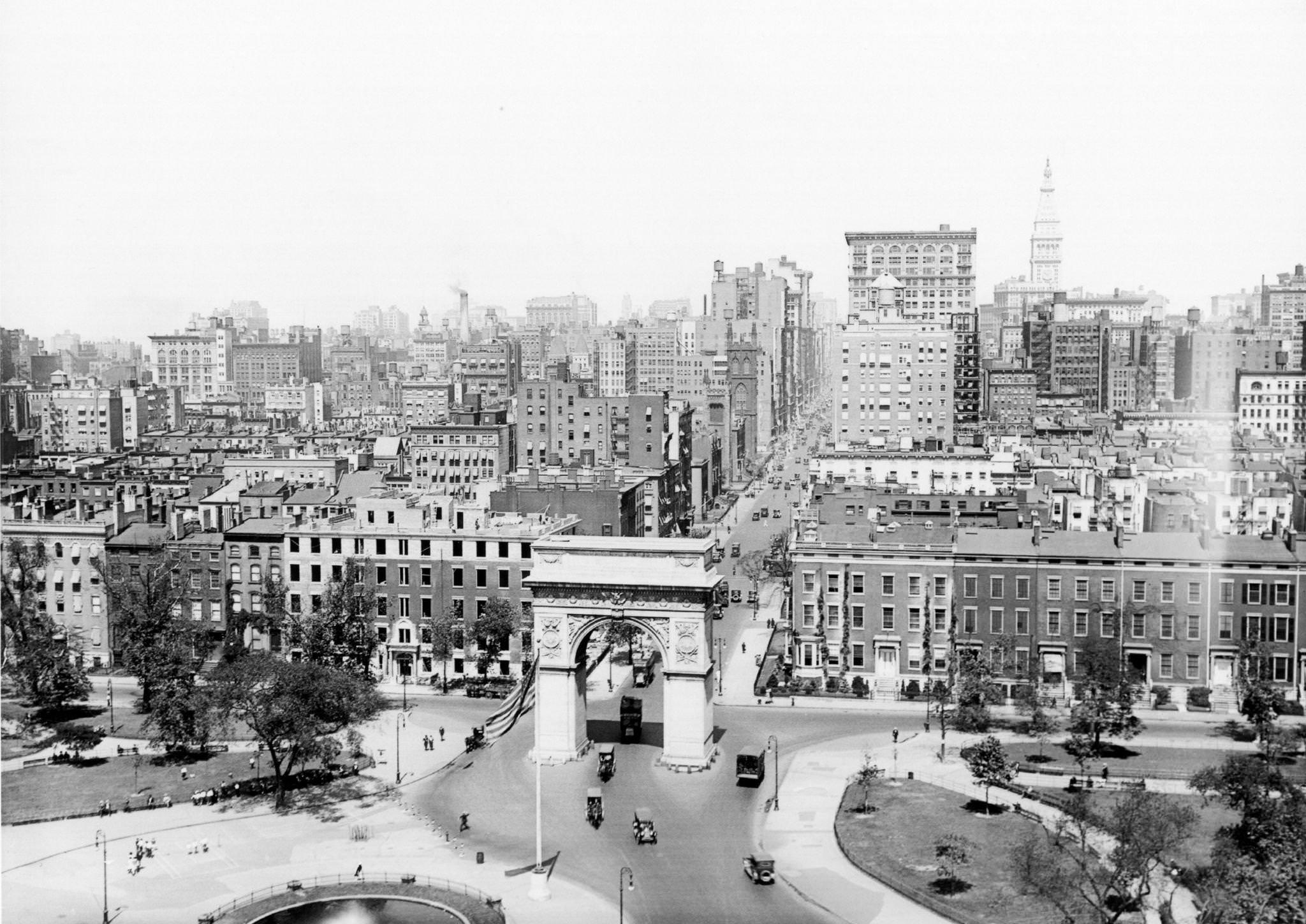 View, looking north, at Washington Square Park, with traffic visible as it enters through the arch off Fifth Avenue, 1920
