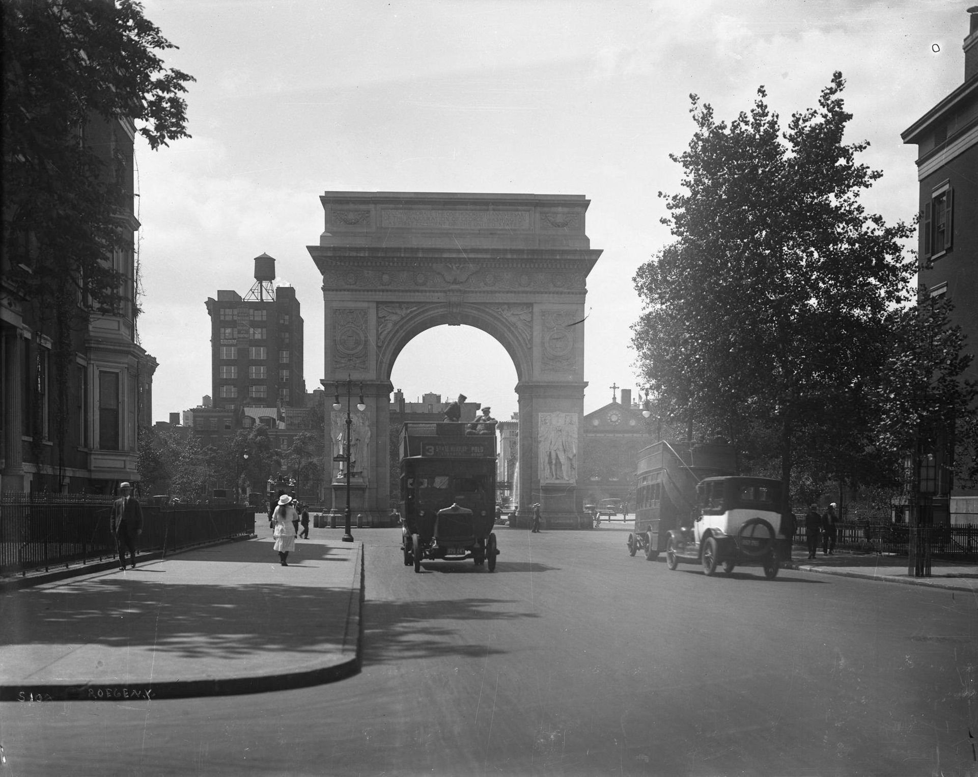 Fifth Avenue near 8th Street, looking south towards Washington Square Arch, with pedestrians and double decker bus, 1920s