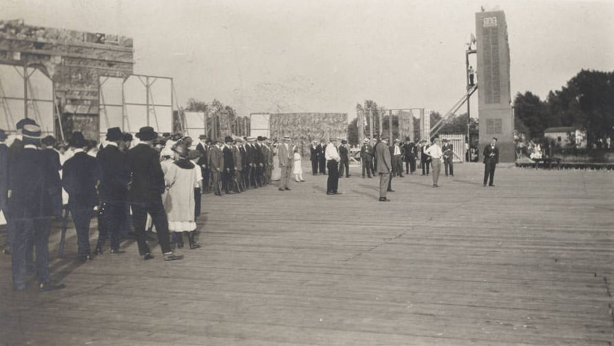 Men, women and children in what may be a rehearsal are on the stage of the Pageant and Masque of St. Louis. Joseph Lindon Smith, director of the Masque, appears in shirt sleeves to the right of the photograph. More than 7500 St. Louis citizens volunteered for the event in Forest Park