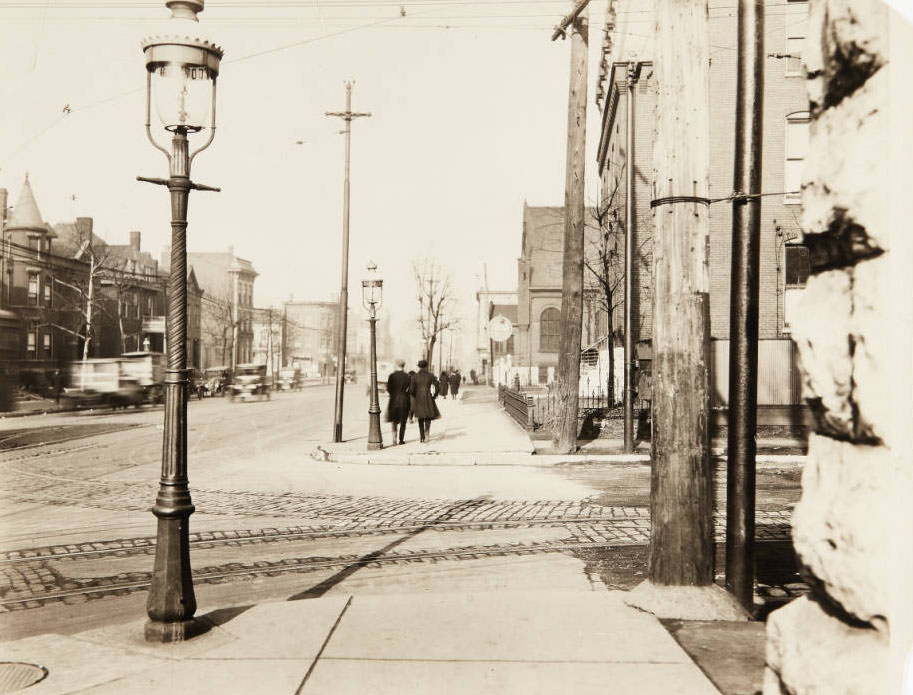 People walking along the sidewalk near the intersection of North Grand Blvd. and Cook Avenue, 1915