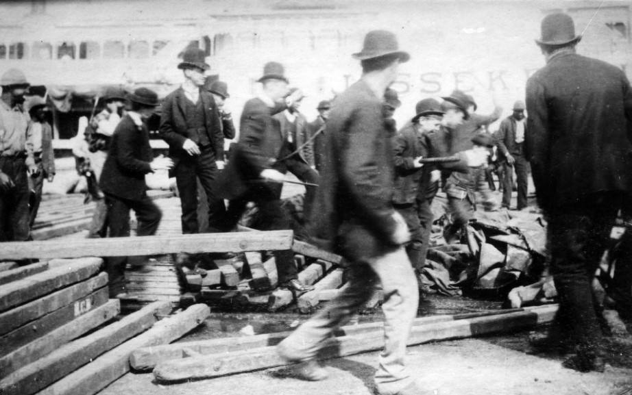 Crowd of men with the steamer JESSE K. BELLE in background, 1880