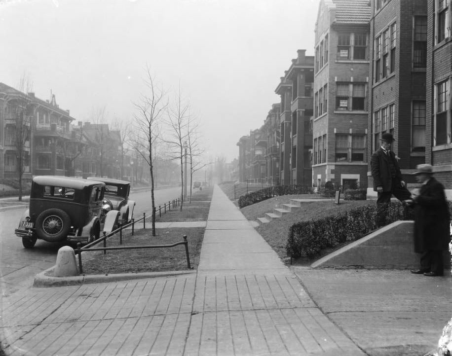The view north down Blair Ave. from just north of O’Fallon Street, 1925. The building on the left is 1311 Blair Ave. Two men stand at a driveway on the right.