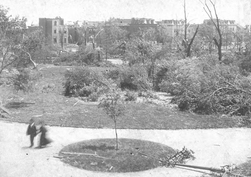 A few people walk among the ruins of Lafayette Park.