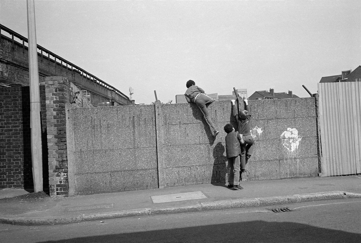 Boys climbing over wall, Kennington, 1982
