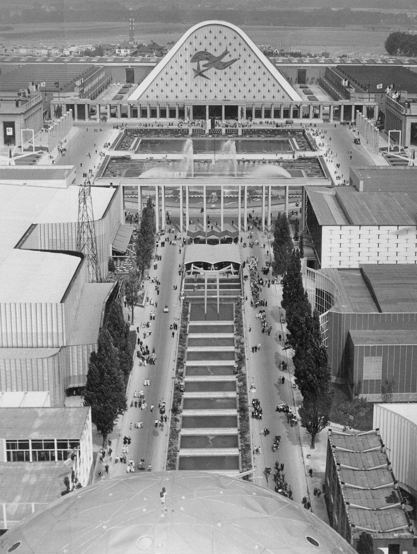 Visitors in front of an exhibition building with pool