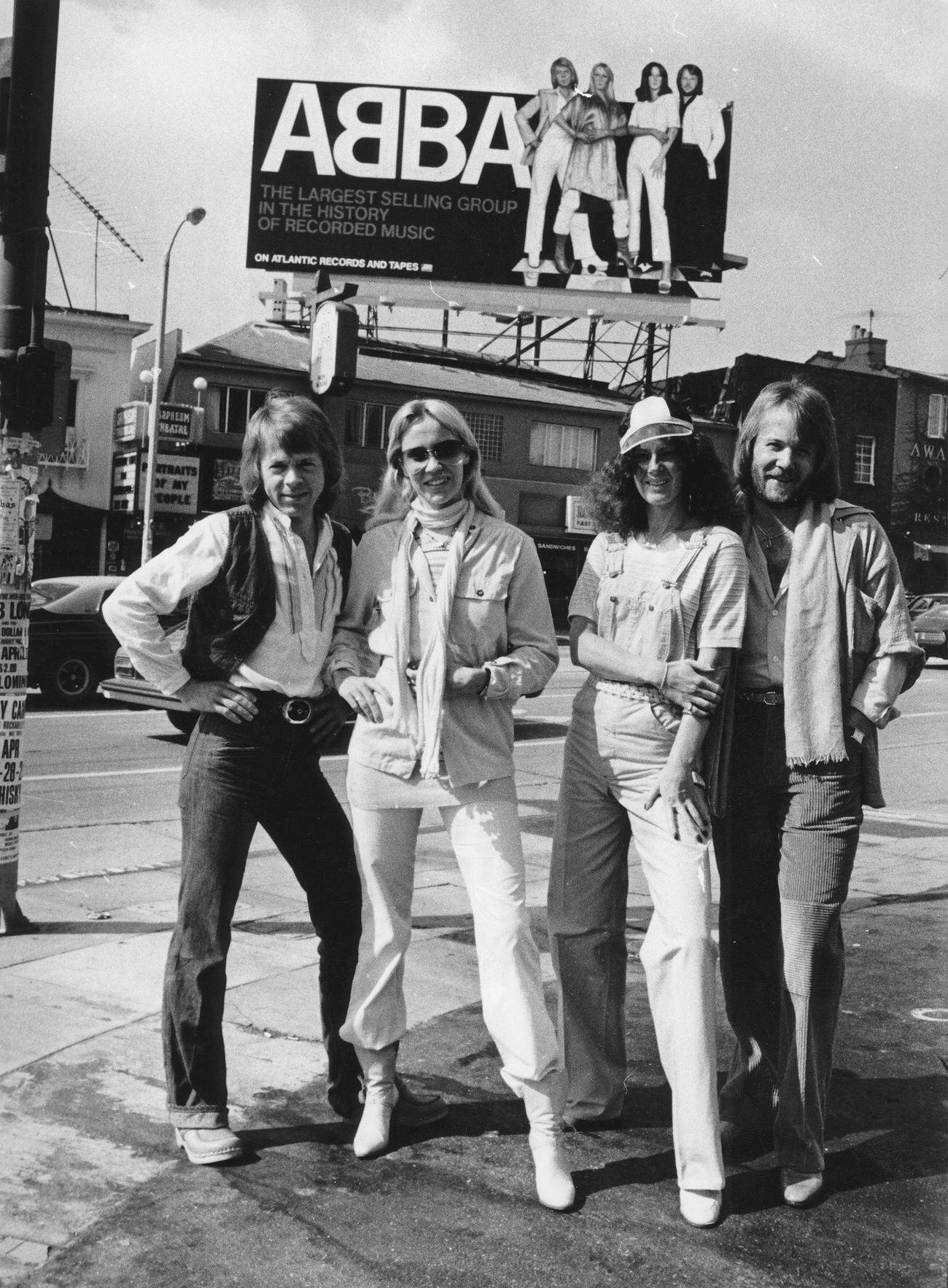 ABBA, from left to right: Björn Ulvaeus; Agnetha Fältskog; Anni-Frid Lyngstad and Benny Andersson in front of a 7 high Poster of themselves in Los Angeles, 1978