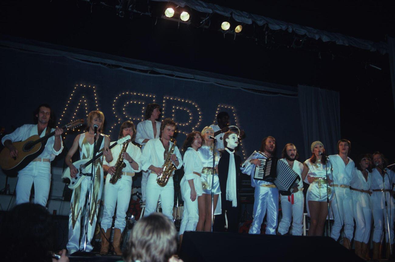 Bjorn Ulvaeus, Agnetha Faltskog, Anni-Frid Lyngstad and Benny Andersson on stage with their backing band in 1977.