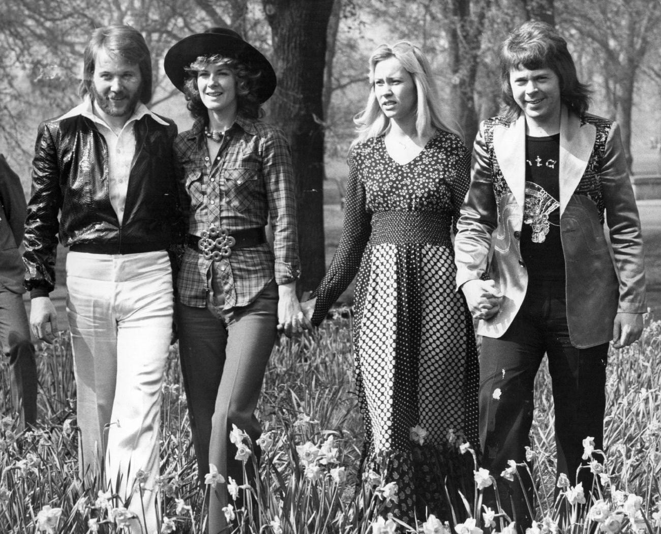 Abba, winners of the 1974 Eurovision Song Contest at Brighton, strolling hand in hand amongst the daffodils in Hyde Park, London.