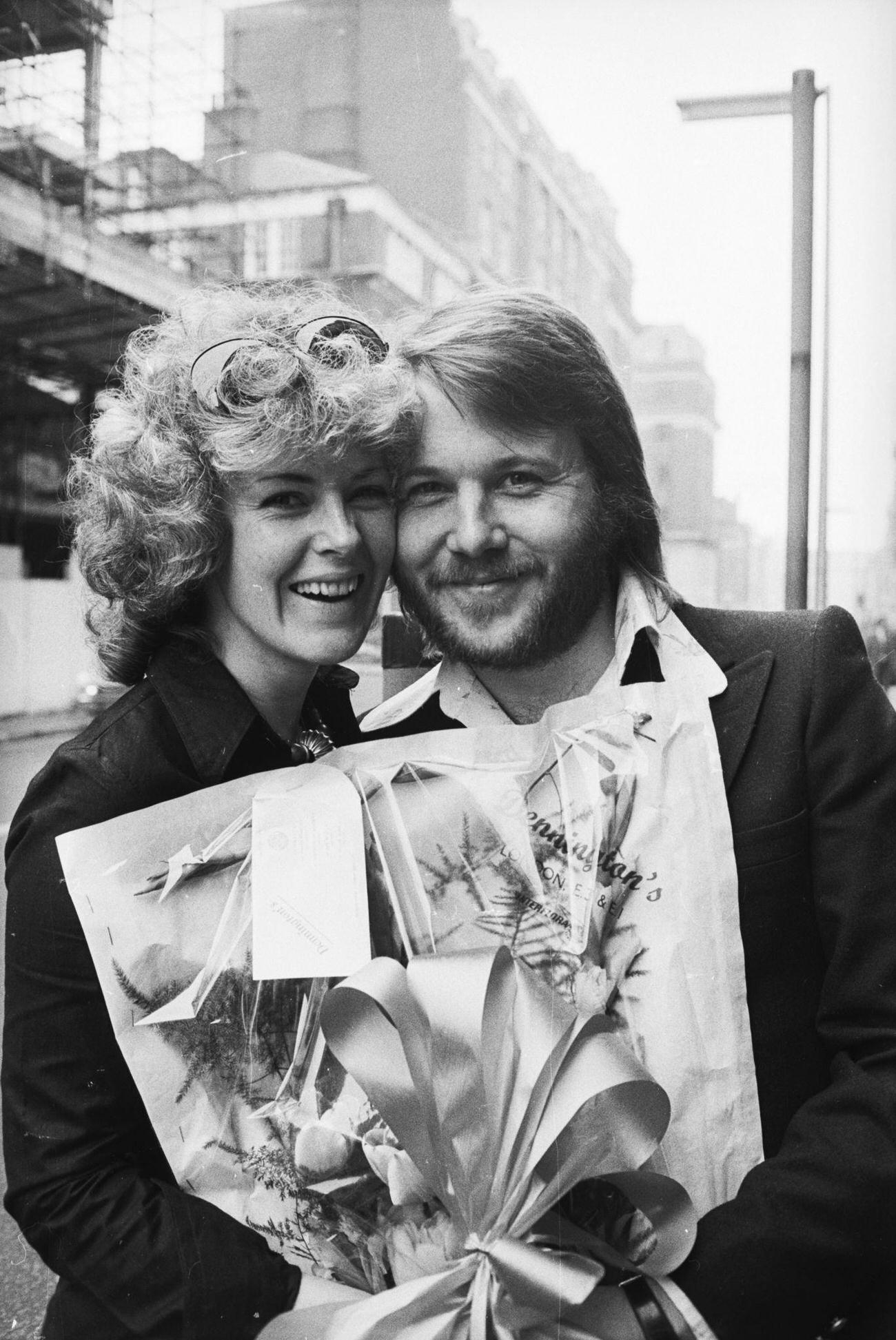 Anni-Frid Lyngstad and Benny Andersson of the Swedish pop group, ABBA, carrying a bouquet, 1974