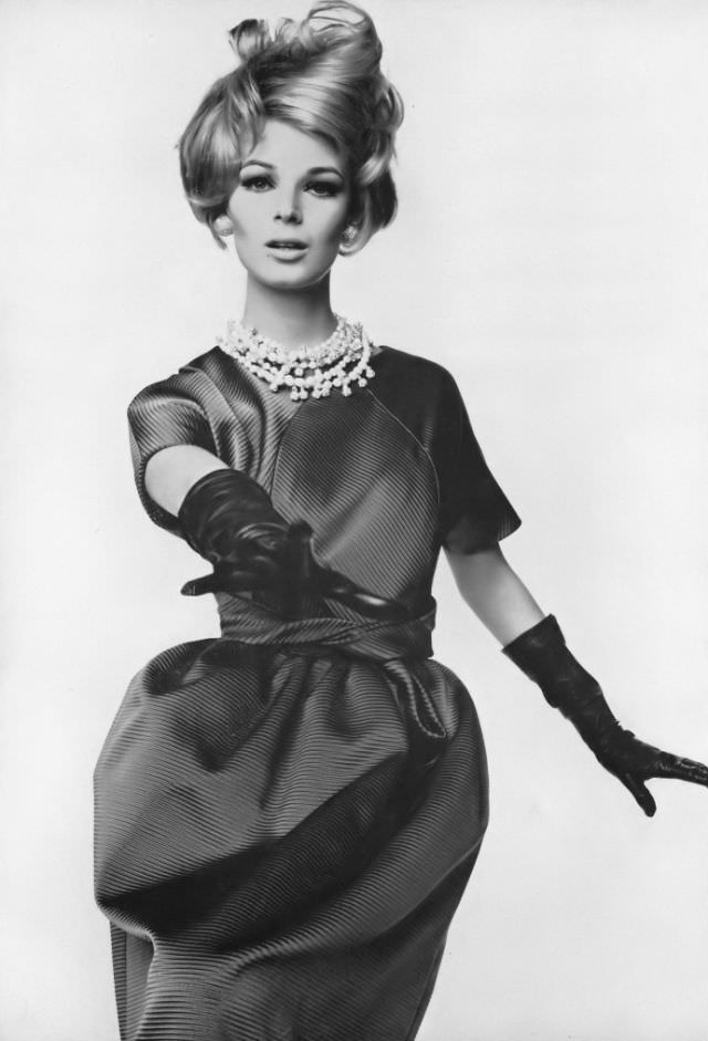 Anne de Zogheb in deep blue ottoman shell top with rounded seaming worn with short skirt puffed under a loopy sash, by Givenchy, necklace by Richelieu, coiffure by Verdi, Vogue, November 15, 1962