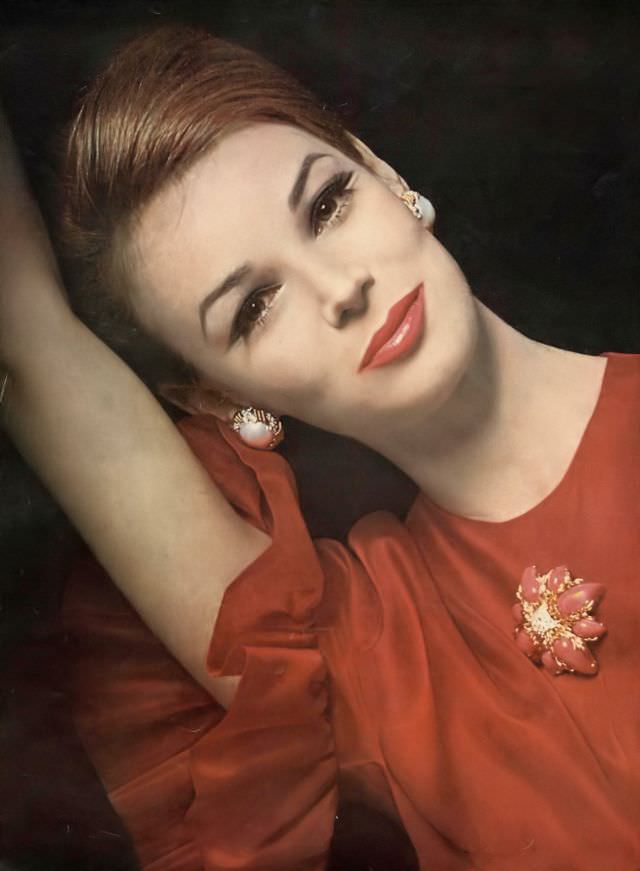 Anne de Zogheb in ruffled cranberry blouse of doubled silk organza over a China silk lining by Sarff-Zumpano to order at Henri Bendel, Pure Cranberry lipstick by Coty, Vogue, July 1962
