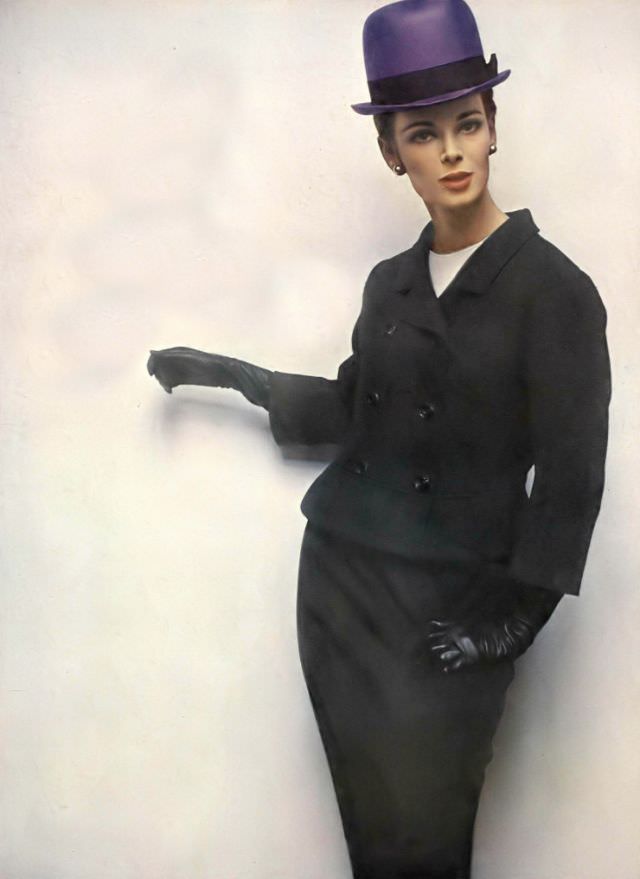 Anne de Zogheb in black lightweight tweed suit, jacket flipped out at the hips over white silk blouse by George Carmel, violet straw bowler by Gustave Tassell, Vogue, January 15, 1963