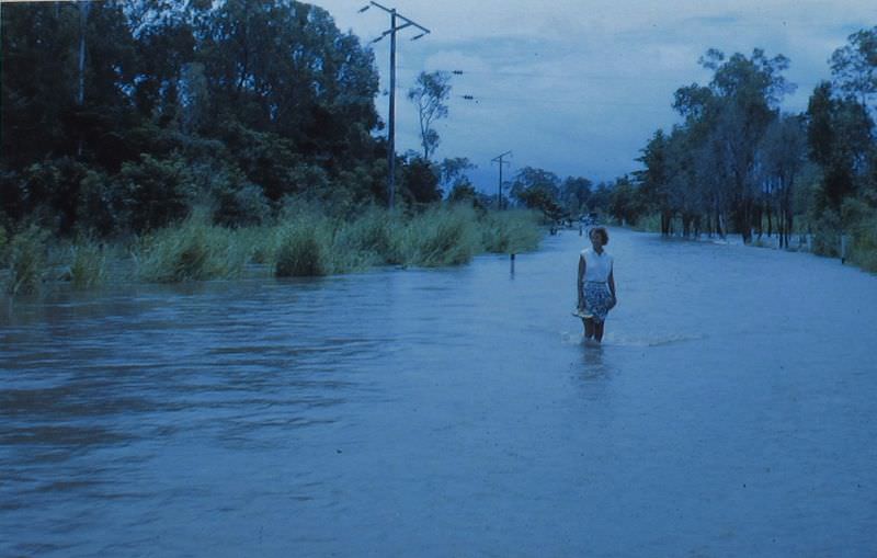 Betty in flooded road, Queensland, January 1963