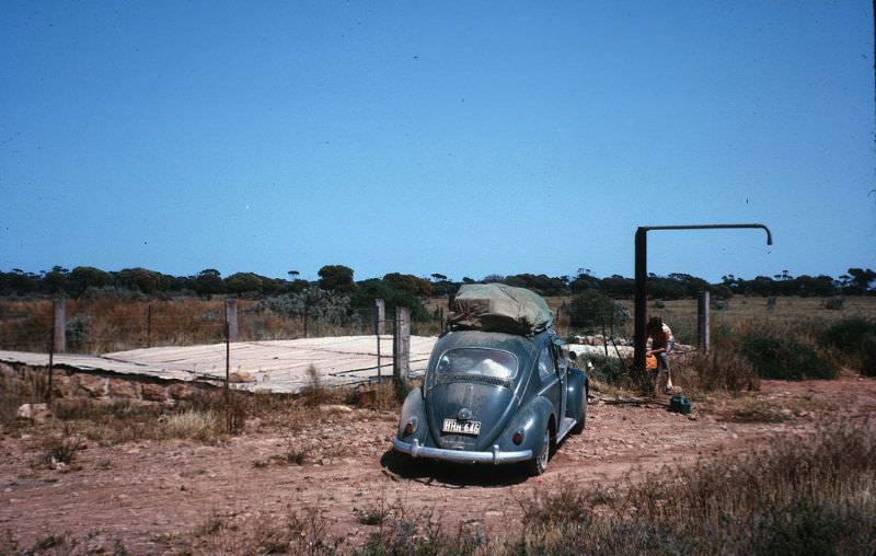 Filling water can before Eucla, Nullarbor water tank, Oct 1963