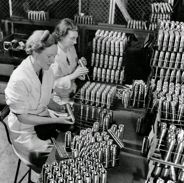 Two women inspecting empty anti-aircraft shell cases before they are filled in a munitiions factory in South Australia.