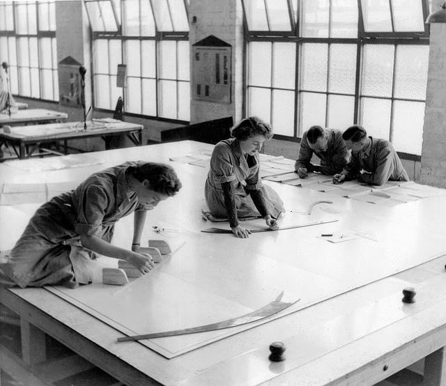 Two young women drawing plans of Beaufort bomber with two military men study plans.