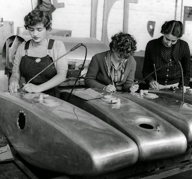 Three young women cleaning dust from the interiors of Beaufort bomber oil tanks.