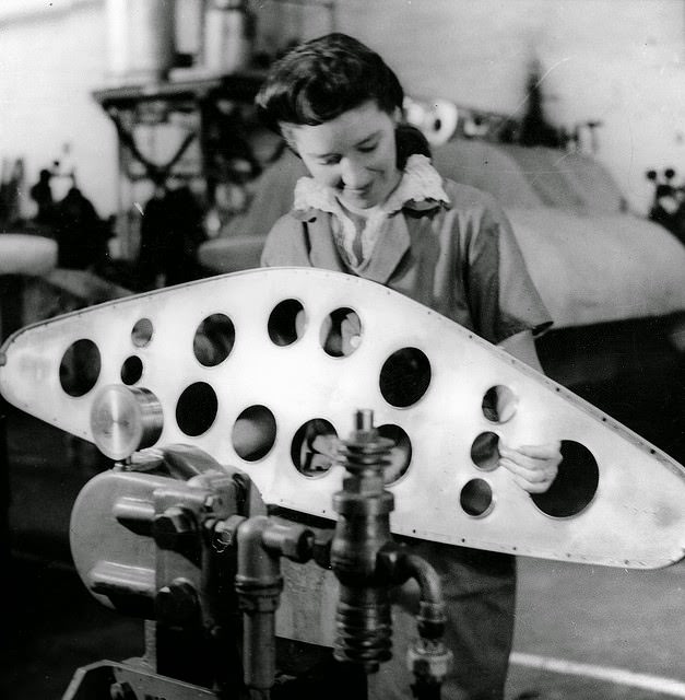 A young woman riveting ribs of a Beaufort bomber with an automatic machine.