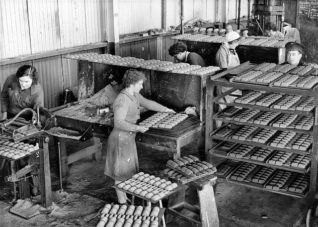 Women working in a munitions factory preparing sand cores for practice bomb bodies.