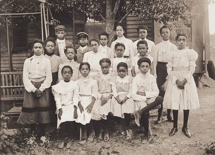 Eighteen Girls and Boys at Sunday School. These girls and boys are probably Sunday School students from Bethel AME Church, dressed in black and white for the communion service held once a month, a tradition that continues to this day. 1901.