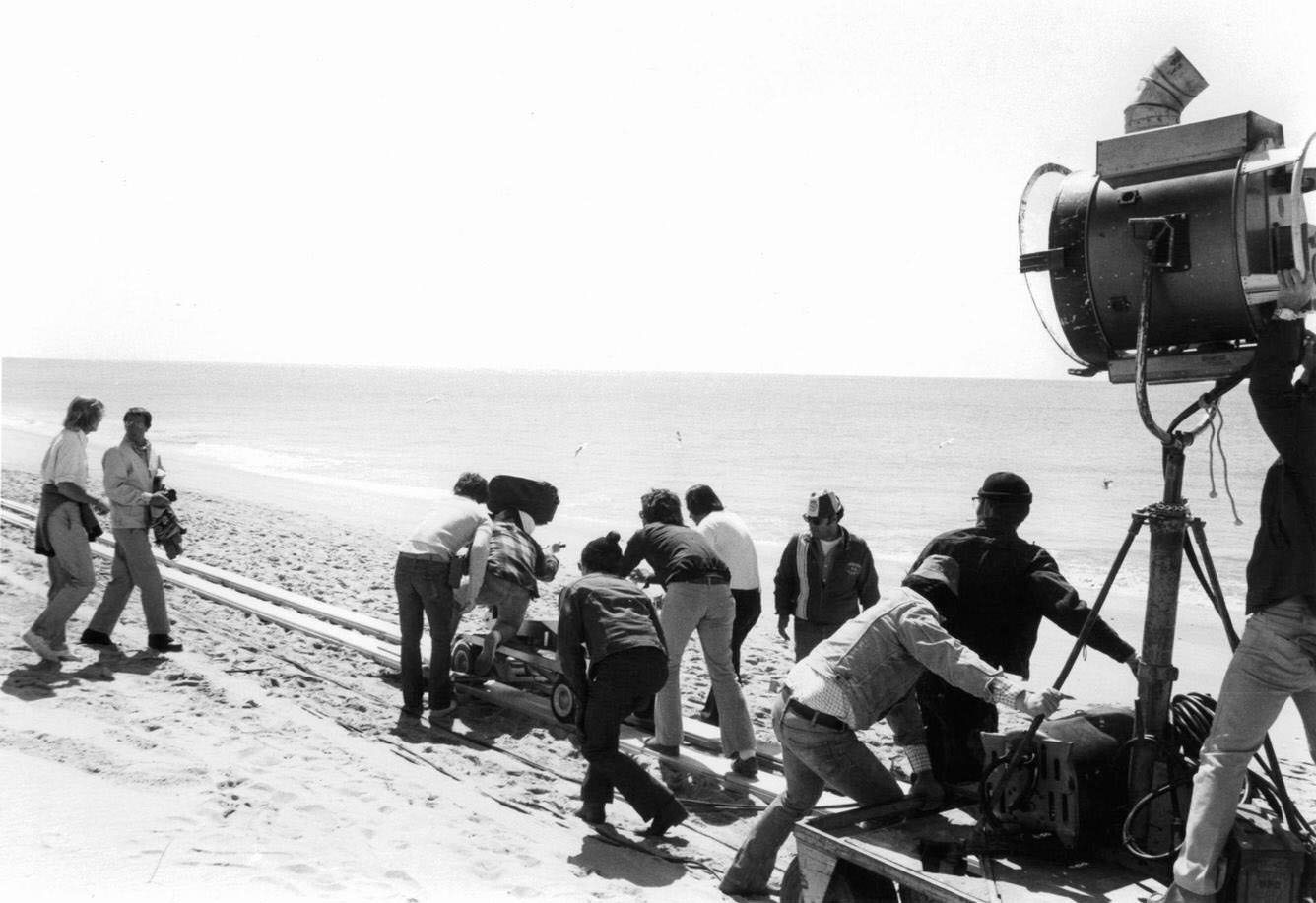 Roy Scheider (2nd left) on beach as crew films in a scene from 'Jaws', 1975.