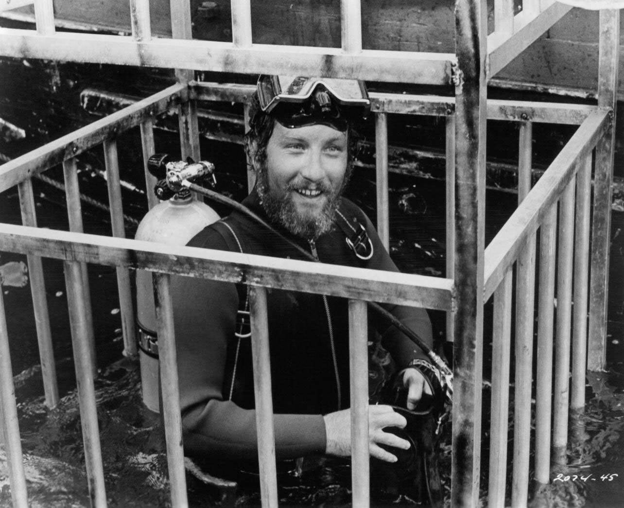 Richard Dreyfuss is lowered into the water in a diving cage in a scene from the film 'Jaws', 1975.