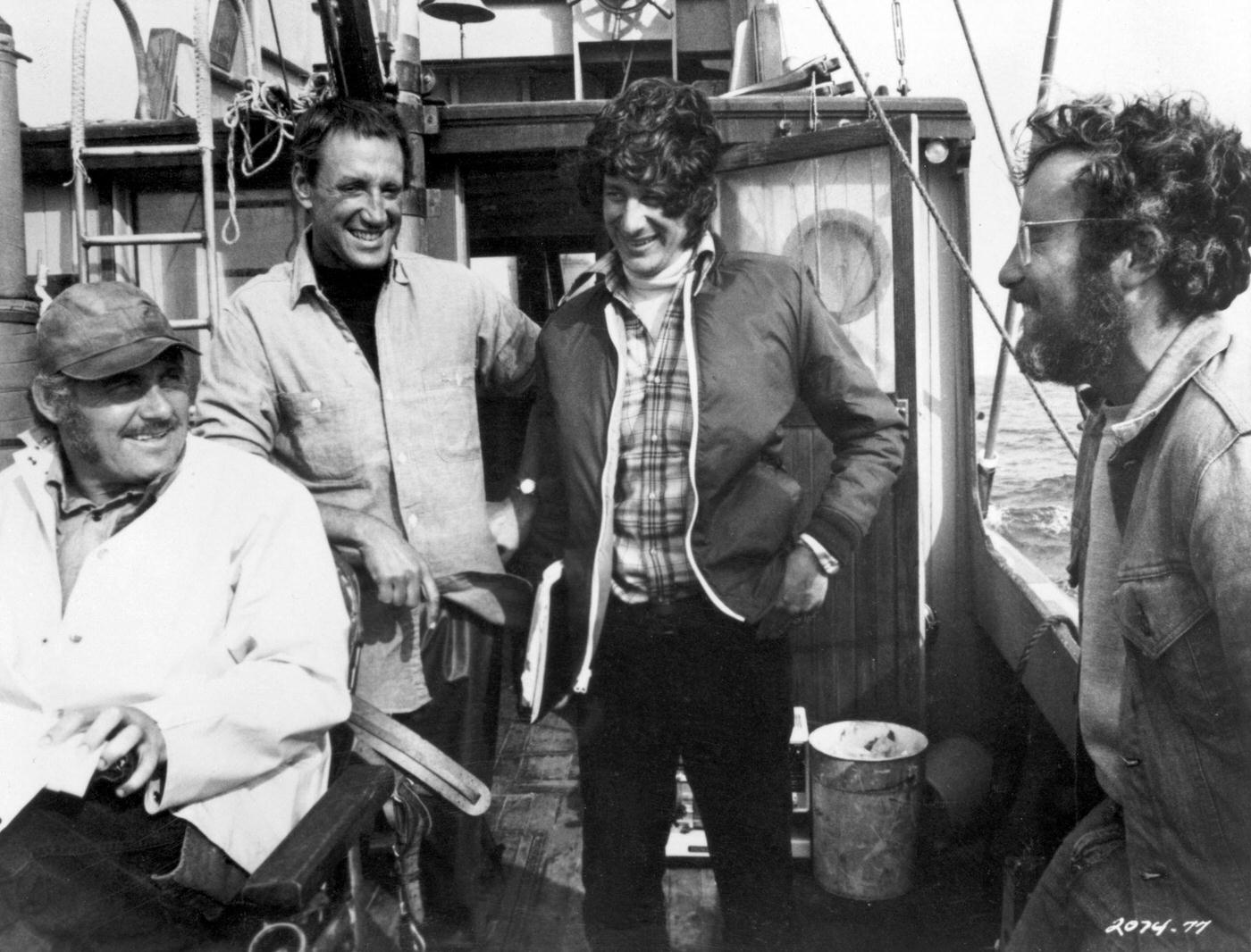 British actor Robert Shaw, American actor Roy Scheider, American director Steven Spielberg, and American actor Richard Dreyfuss laugh together on a boat during the filming of Spielberg's 'Jaws', 1975