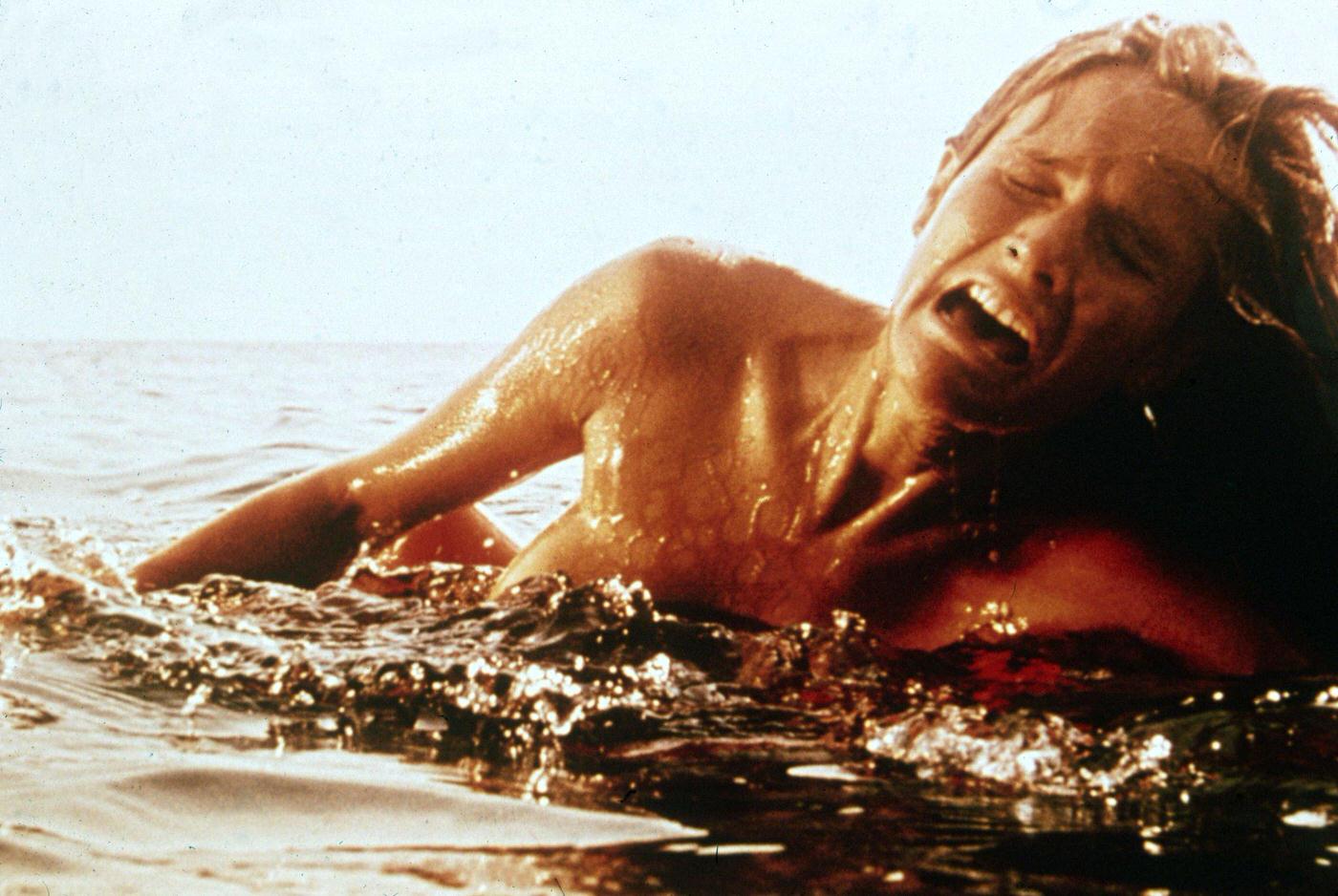 A female swimmer screams as she is attacked by a giant Great White shark (not pictured) in a still from the film 'Jaws,' 1975