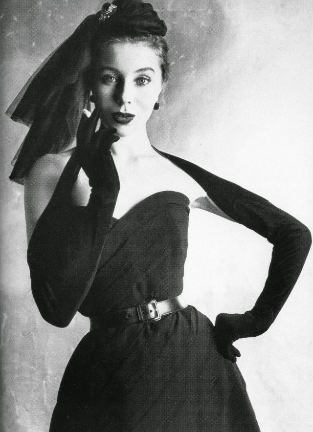 Bettina in strapless belted dress of tucked silk crepe by Dior with bretelle gloves buttoning at the back, 1950