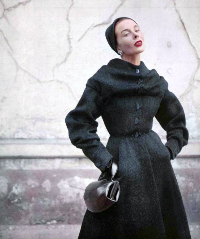 Bettina in furry wool redingote with cape-like shawl clasped over shoulders, fastened with whimsical half buttons, by Jean Dessès, 1952