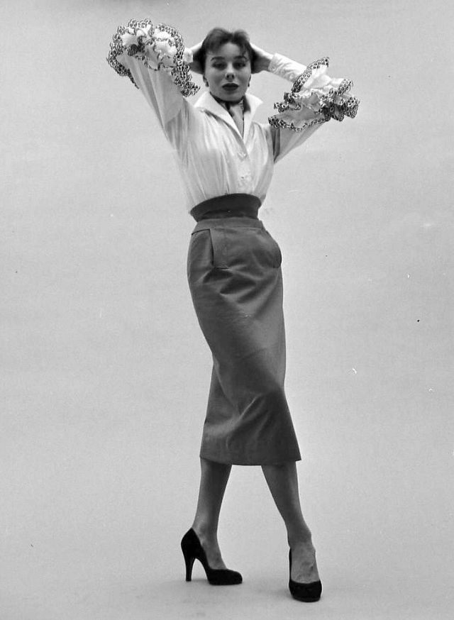 Bettina in Givenchy's cotton blouse with black embroidered ruffles called "Blanchisseuse" (washerwoman) tucked into a slim gabardine skirt, February 1952