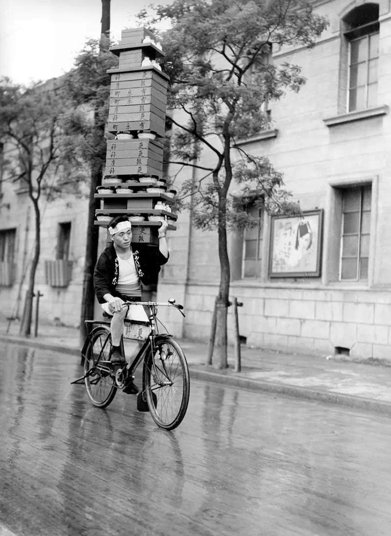 Soba noodles deliveryman in Tokyo, 1935. Photo by the Mainichi Shimbun. Piles of soba bowls were packed on the shoulders of bicycle couriers.