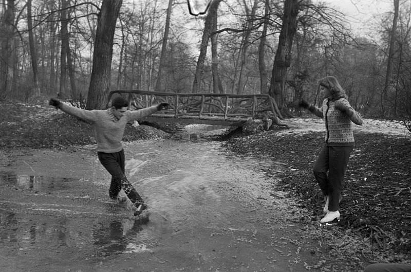 A man showing his friend how to skate.