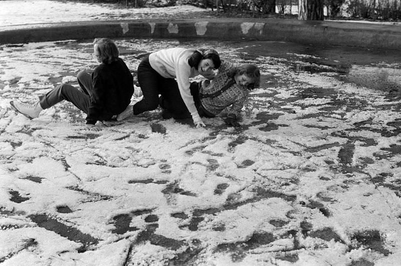 Young people having fun with their fall on the frozen lake.