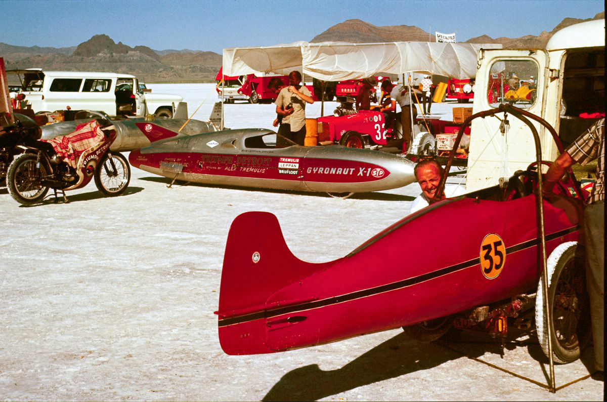 Bert Munro works on his streamlined Indian Scout with an Alex Tremulis-designed Detroit Triumph Gyronaut X-1 in the background.